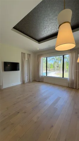 a view of an empty room with furniture and windows