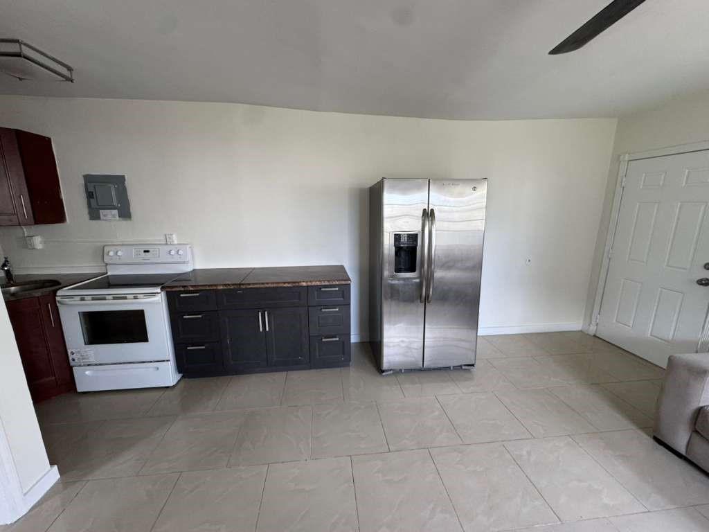 1042 Foster Road Hallandale Beach, FL 33009 - Photo 4 of 8 a kitchen with stainless steel appliances granite countertop a stove a sink and a refrigerator