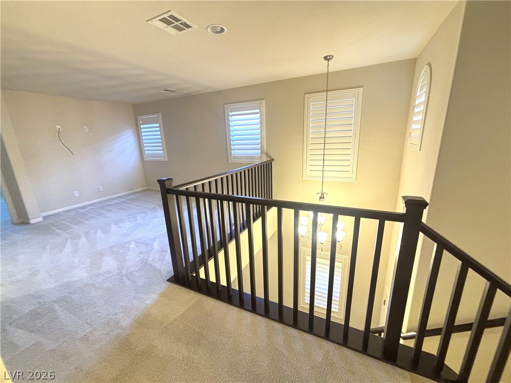 121 Elm Reed Avenue Las Vegas, NV 89113 - Photo 16 of 30 A graceful staircase with dark wood railings connects two levels of a well-appointed home.