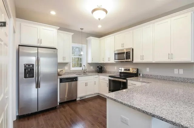 a kitchen with granite countertop stainless steel appliances cabinets a sink and a counter space