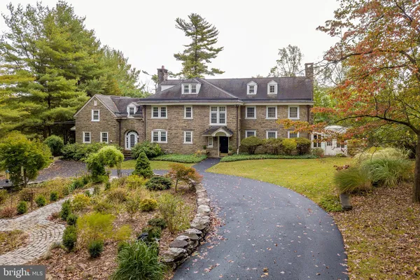 a view of a house with a big yard and large trees