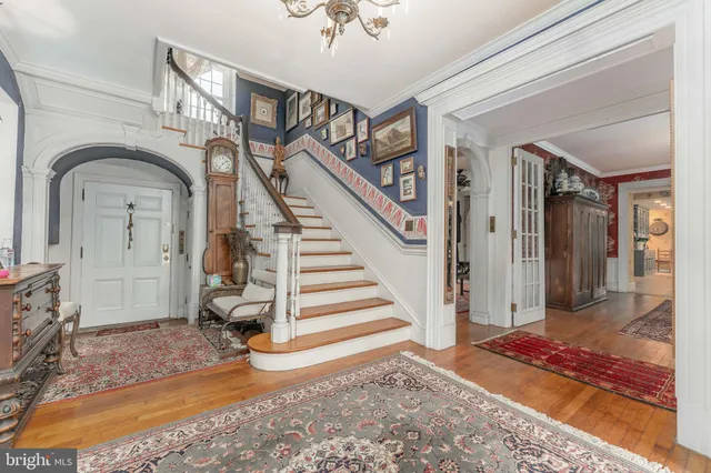 a view of a dining room with furniture a chandelier and wooden floor