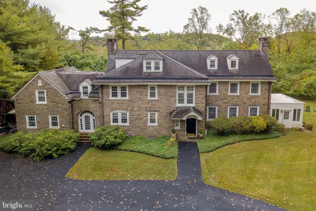 a view of a big house with a big yard and large trees