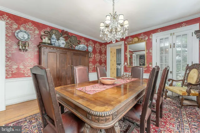 a view of a patio with table and chairs under an umbrella with large trees