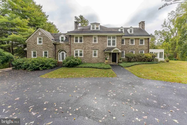 a view of a big house with a big yard and large trees