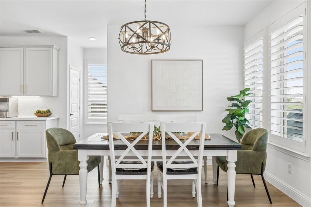 3200 Willowbrook Road Northlake, TX 76226 - Photo 9 of 29 Elegant dining space featuring a white wood farmhouse table with X-back chairs, paired with olive green upholstered accent chairs