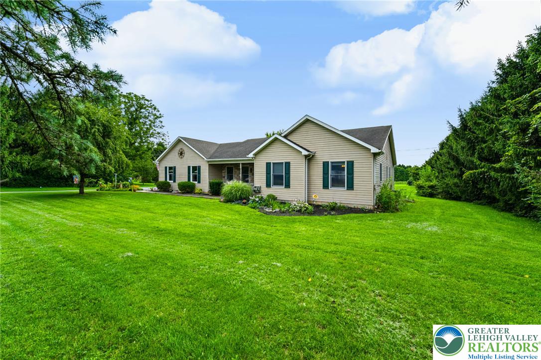 A well-maintained facade with green shutters and mature landscaping, framed by an expansive lawn.