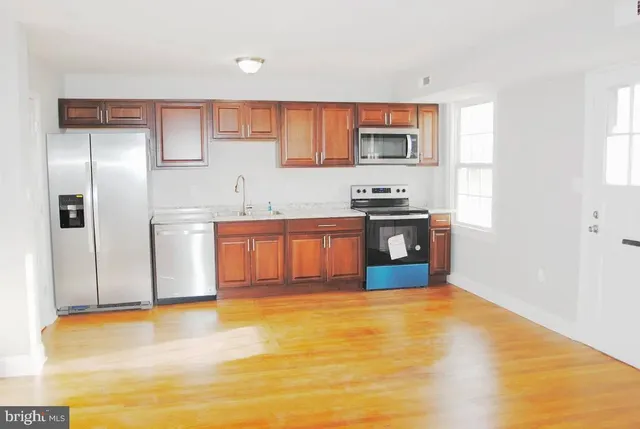 a kitchen with stainless steel appliances granite countertop a refrigerator and a stove top oven
