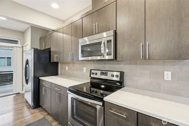 a kitchen with stainless steel appliances a stove a sink and a refrigerator