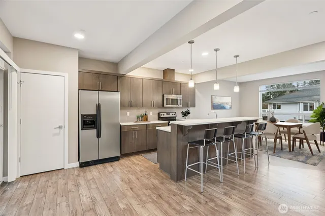 a kitchen with kitchen island granite countertop a sink cabinets and stainless steel appliances