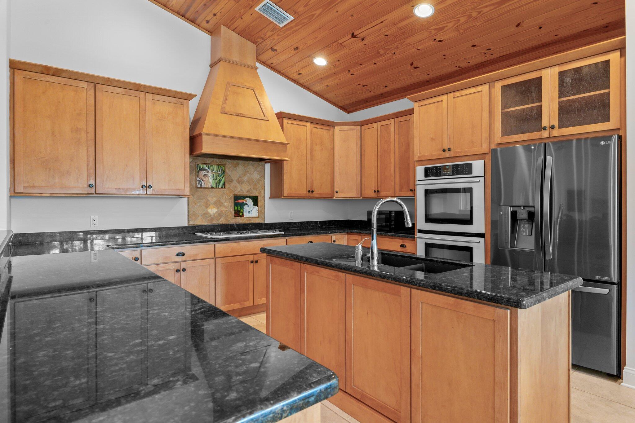 1293 Southwest Heather Terrace Stuart, FL 34997 - Photo 18 of 80 a kitchen with stainless steel appliances granite countertop a stove a sink dishwasher and a refrigerator