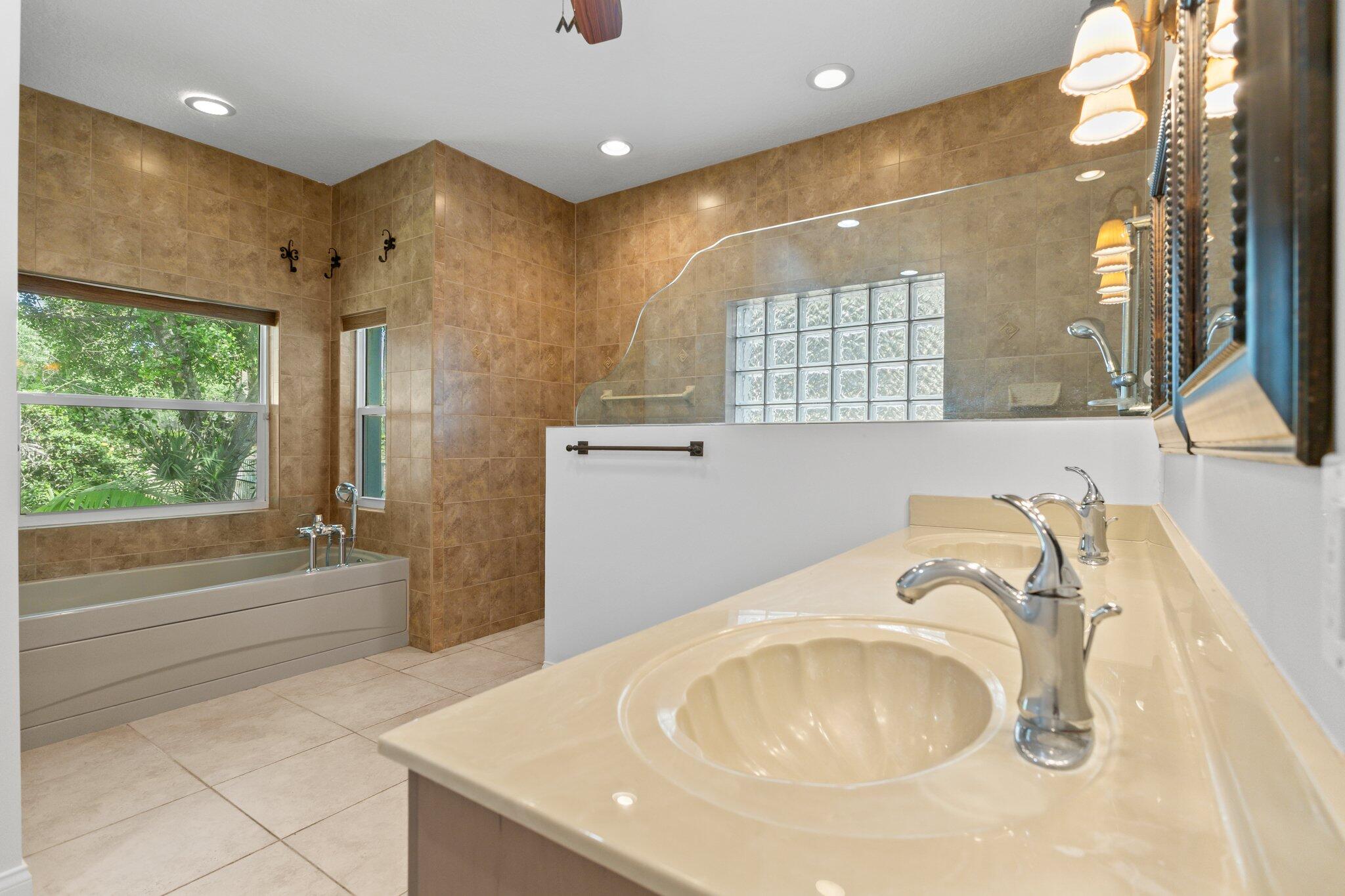 1293 Southwest Heather Terrace Stuart, FL 34997 - Photo 26 of 80 a bathroom with a tub sink and mirror