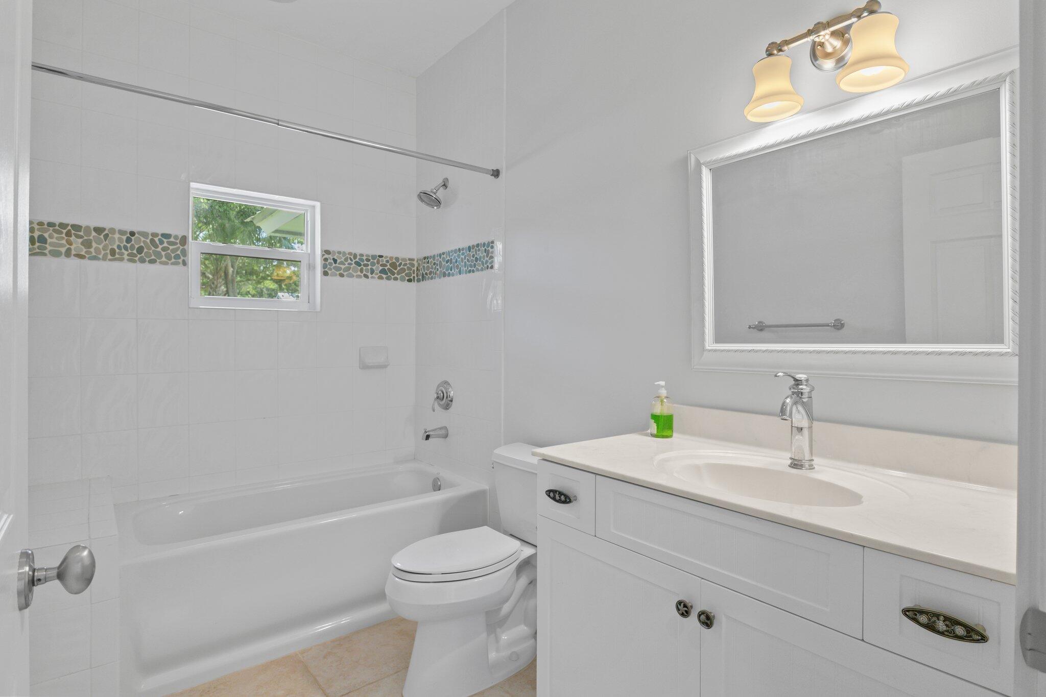 1293 Southwest Heather Terrace Stuart, FL 34997 - Photo 36 of 80 a bathroom with a sink a toilet and shower