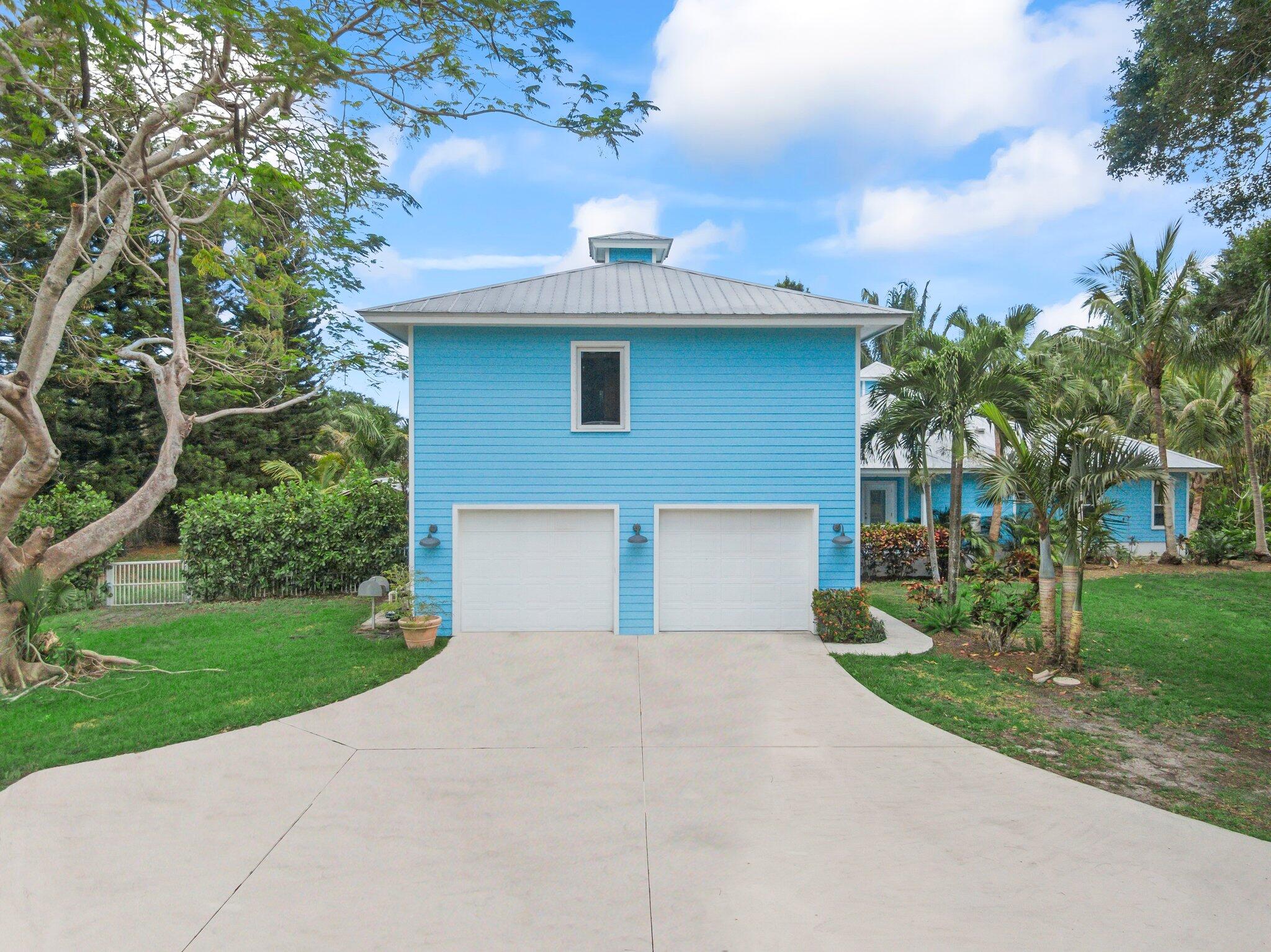 1293 Southwest Heather Terrace Stuart, FL 34997 - Photo 48 of 80 a front view of a house with a yard and garage