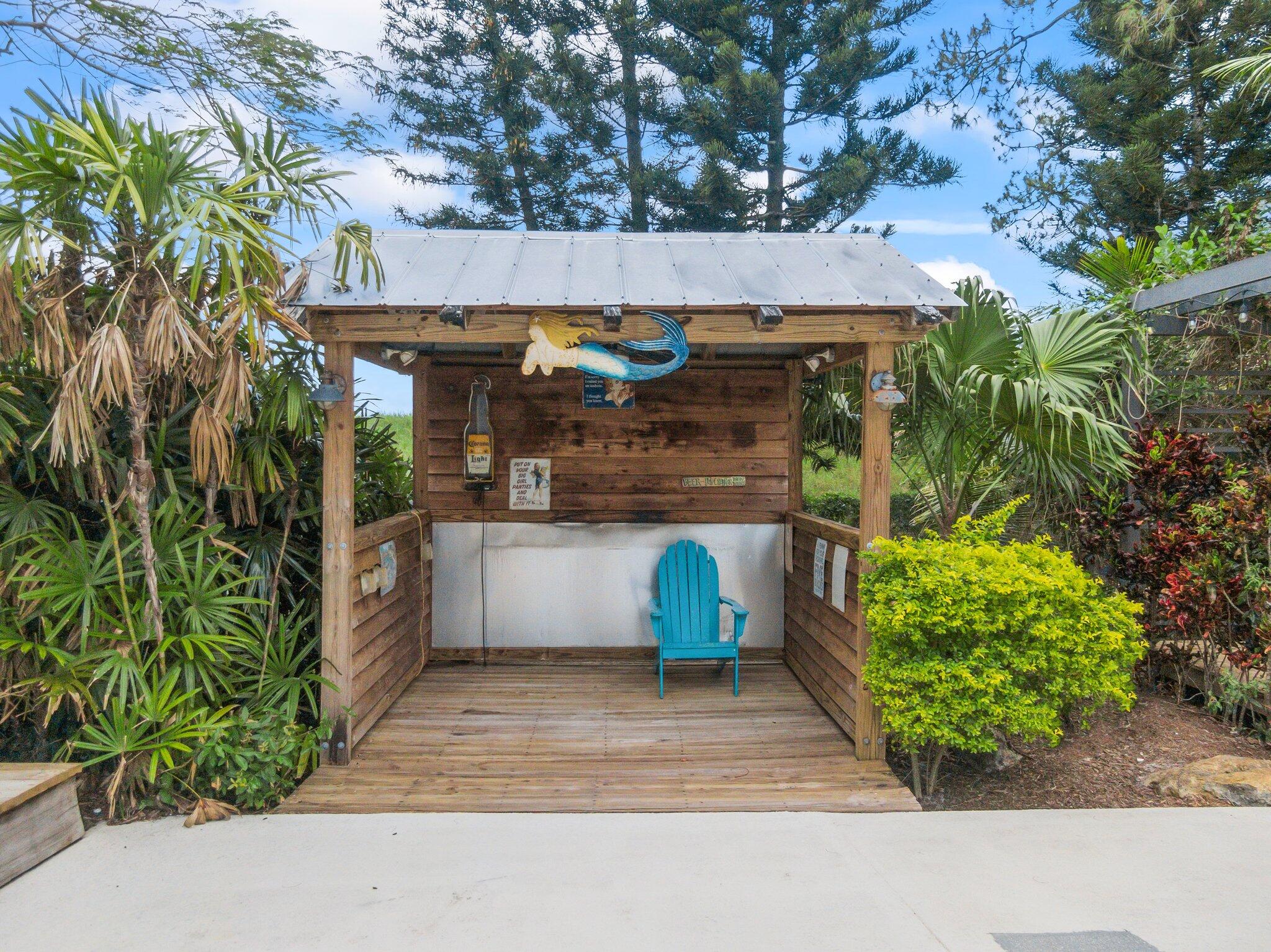 1293 Southwest Heather Terrace Stuart, FL 34997 - Photo 56 of 80 a view of a patio with table and chairs potted plants