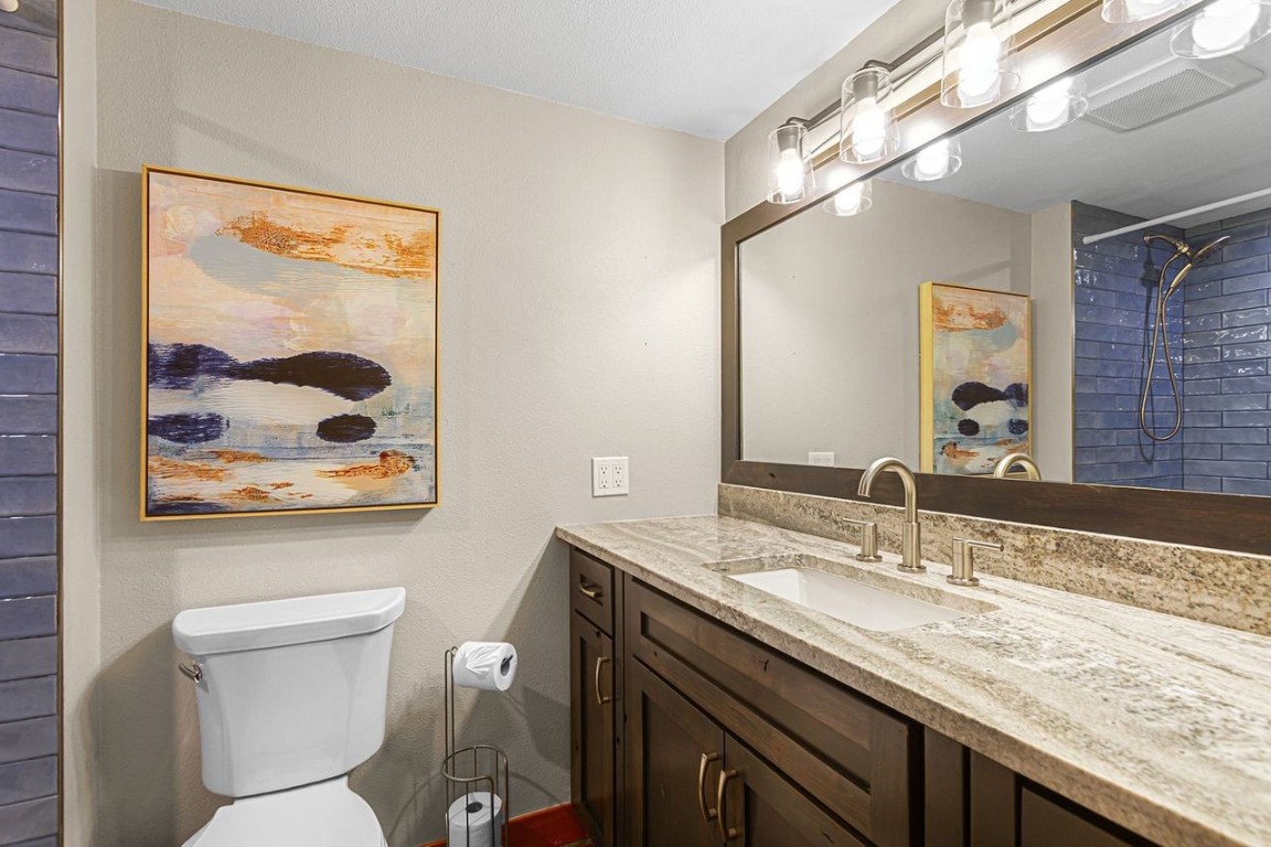 21650 Highway 6, Unit 2110 Keystone, CO 80435 - Photo 18 of 26 a bathroom with a granite countertop toilet a sink and mirror
