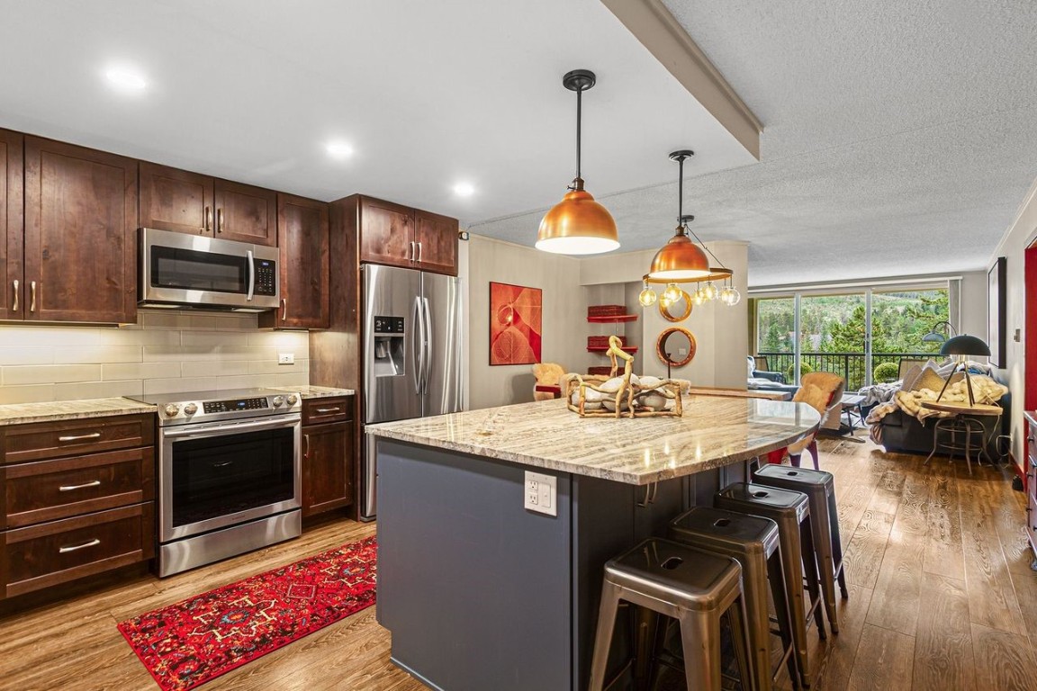 21650 Highway 6, Unit 2110 Keystone, CO 80435 - Photo 2 of 26 a kitchen with stainless steel appliances kitchen island granite countertop a stove a sink dishwasher a microwave oven with granite countertops and cabinets
