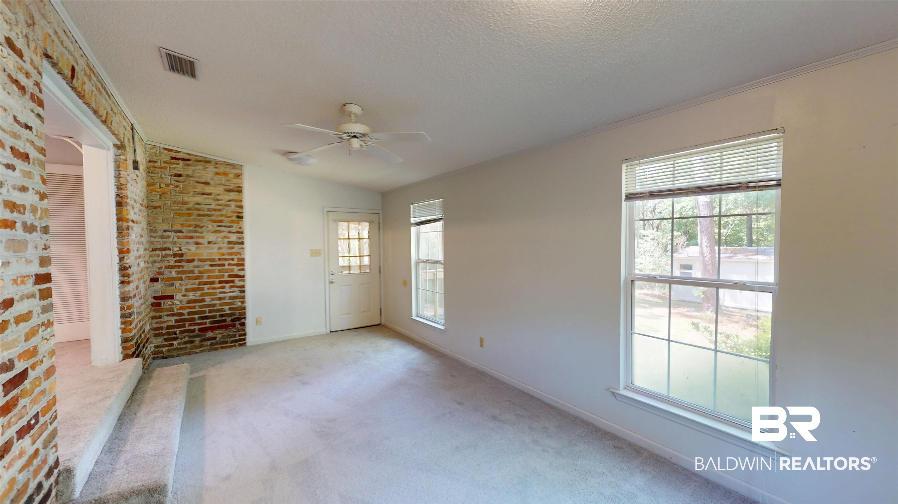 1075 Zurich Street Mobile, AL 36608 - Photo 21 of 35 Empty room with brick wall, ceiling fan, and light carpet