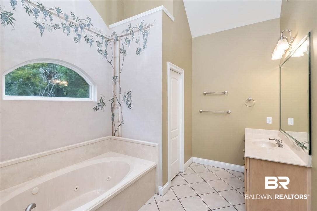 8837 Dawes Lake Road South Mobile, AL 36619 - Photo 20 of 44 Bathroom with lofted ceiling, a tub to relax in, tile patterned flooring, and vanity