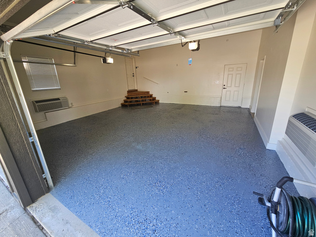 812 East Bates Cyn Road Tooele, UT 84074 - Photo 89 of 144 Spacious garage featuring a durable epoxy floor finish, dedicated door access, interior window with blinds, and built-in wall unit