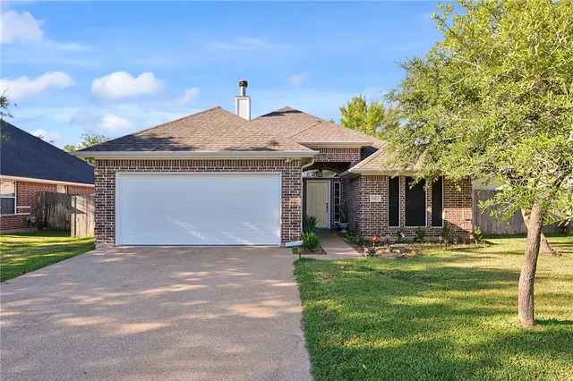 a front view of a house with a yard and trees
