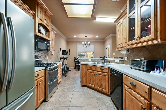 a large kitchen with stainless steel appliances granite countertop a large stove top oven a sink dishwasher and cabinets