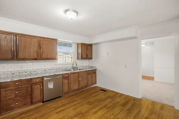 a kitchen with granite countertop a sink and cabinets