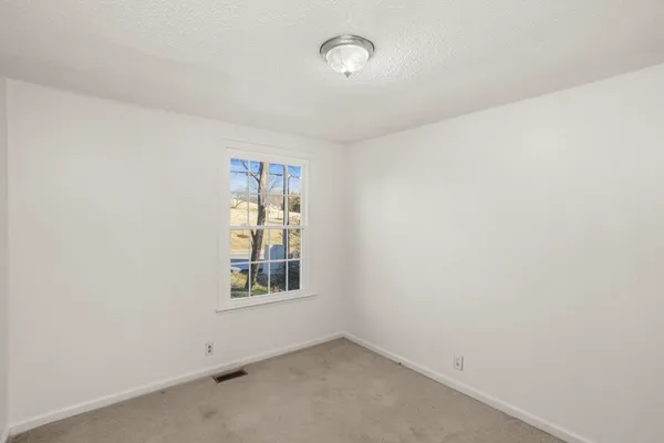 an empty room with windows and closet