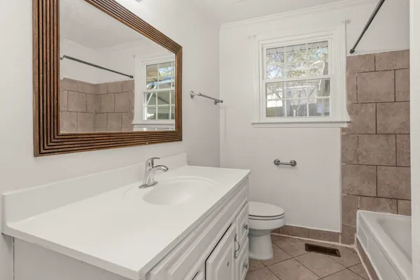 a bathroom with a sink a toilet and a window