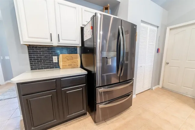 a kitchen with stainless steel appliances kitchen island granite countertop a sink and a refrigerator
