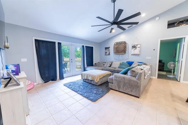 a living room with furniture kitchen view and a chandelier