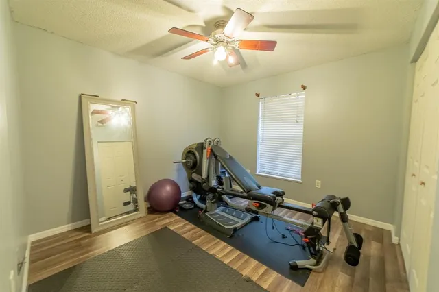 a view of a hallway with wooden floor and living room