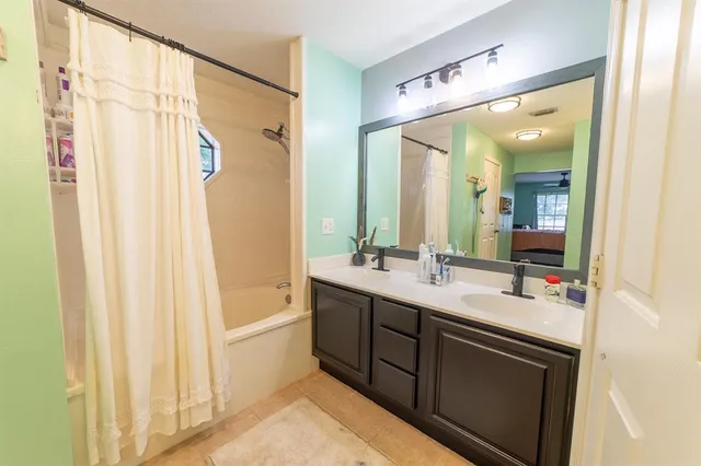 a bathroom with a bathtub a sink and a shower curtain