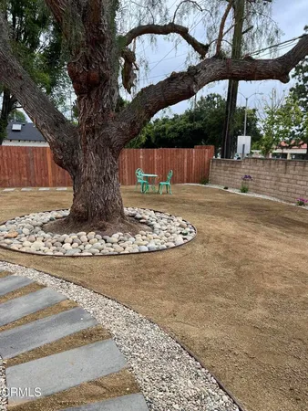 a view of a yard with wooden fence
