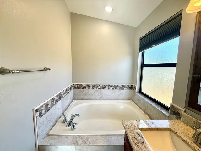 a bathroom with a tub and a window