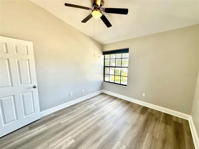 an empty room with windows and fan