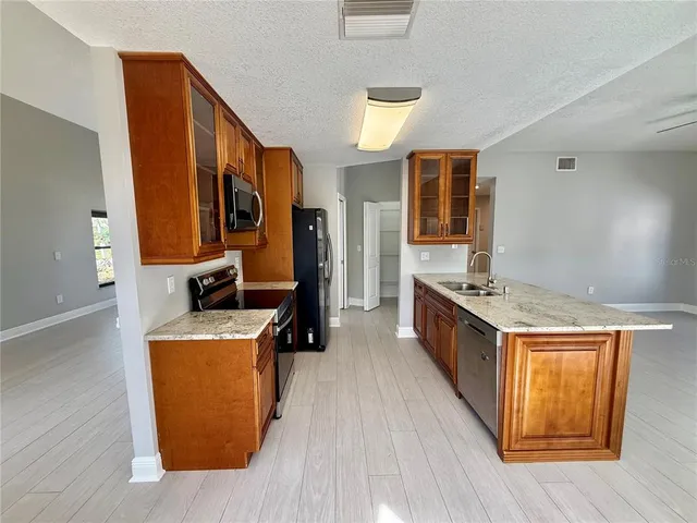 a kitchen with stainless steel appliances granite countertop a stove and a refrigerator