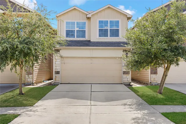 a view of a white house next to a yard