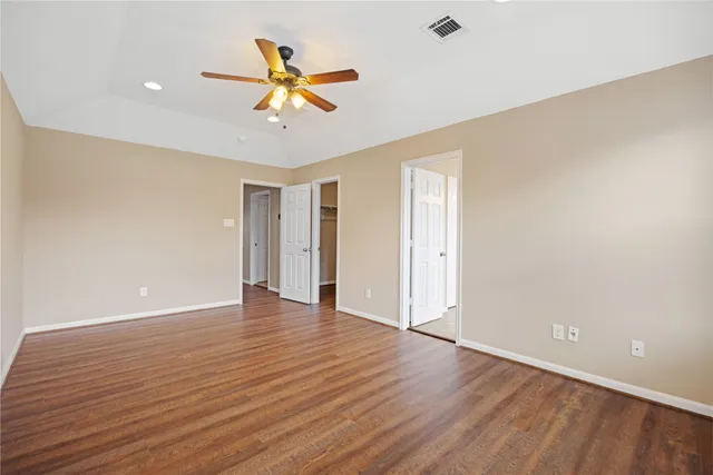 a view of an empty room with window and wooden floor