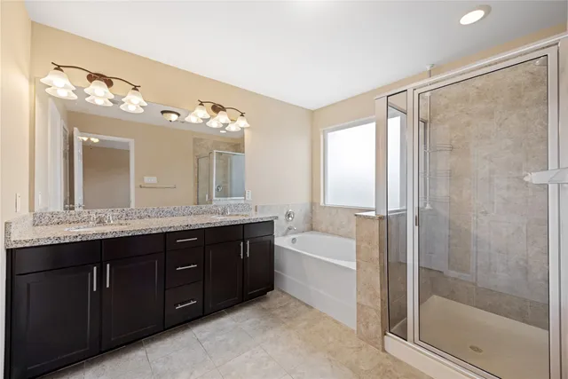 a bathroom with a tub sink shower and mirror