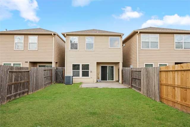 a backyard of a house with barbeque oven and wooden fence
