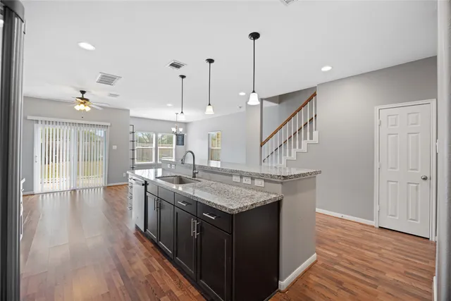 a kitchen with stainless steel appliances granite countertop a stove and a wooden floor