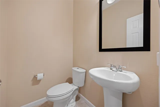 a bathroom with a toilet a sink and mirror