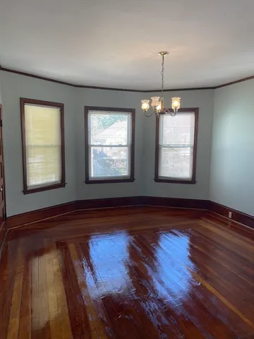 a view of room with wooden floor and windows