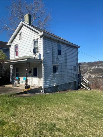 a view of a house with backyard and porch