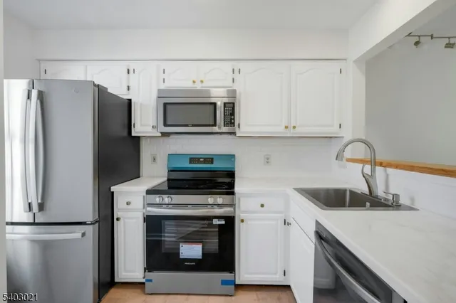a kitchen with cabinets and steel stainless steel appliances