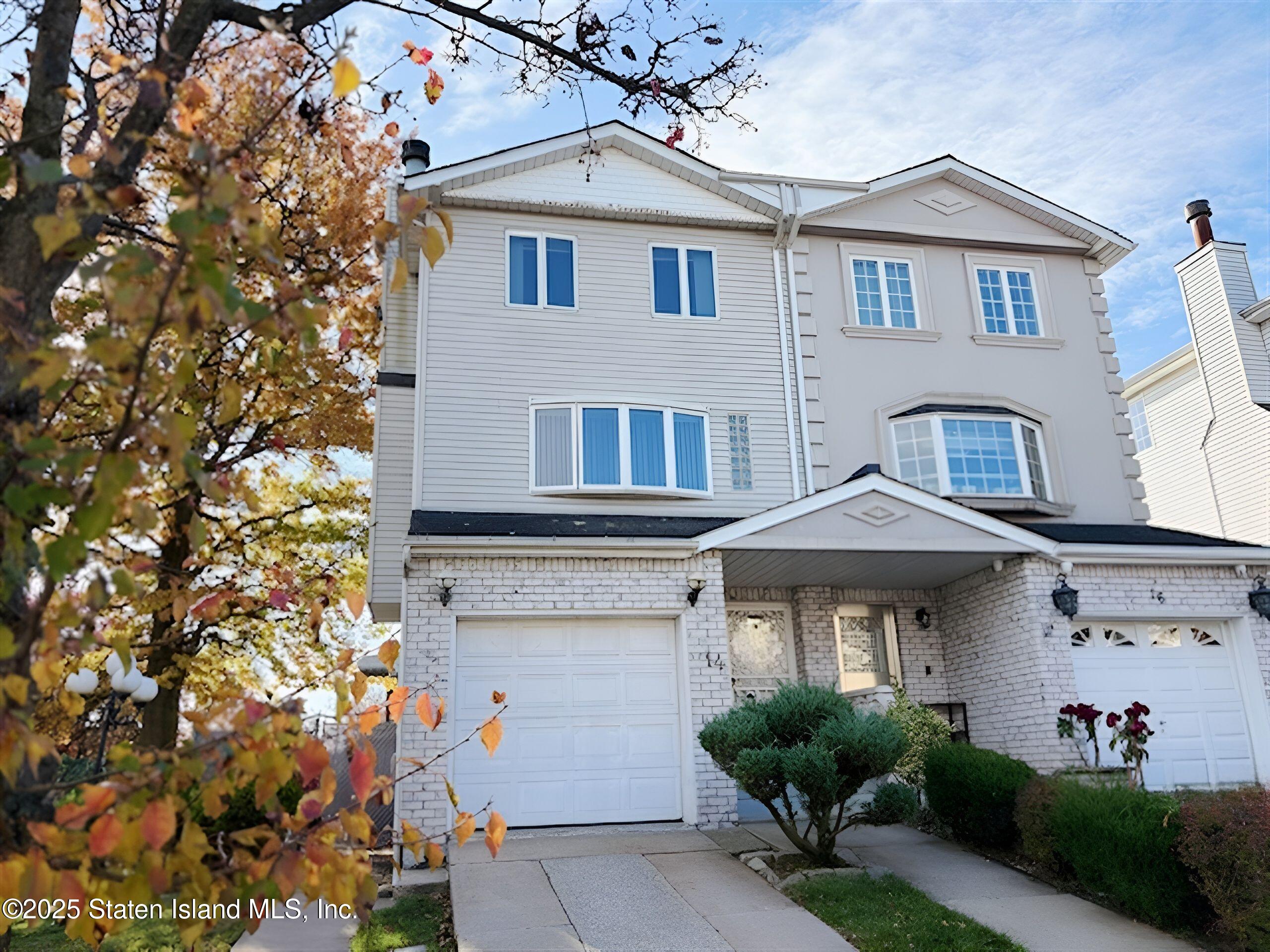 a view of a white house with large windows and a large tree