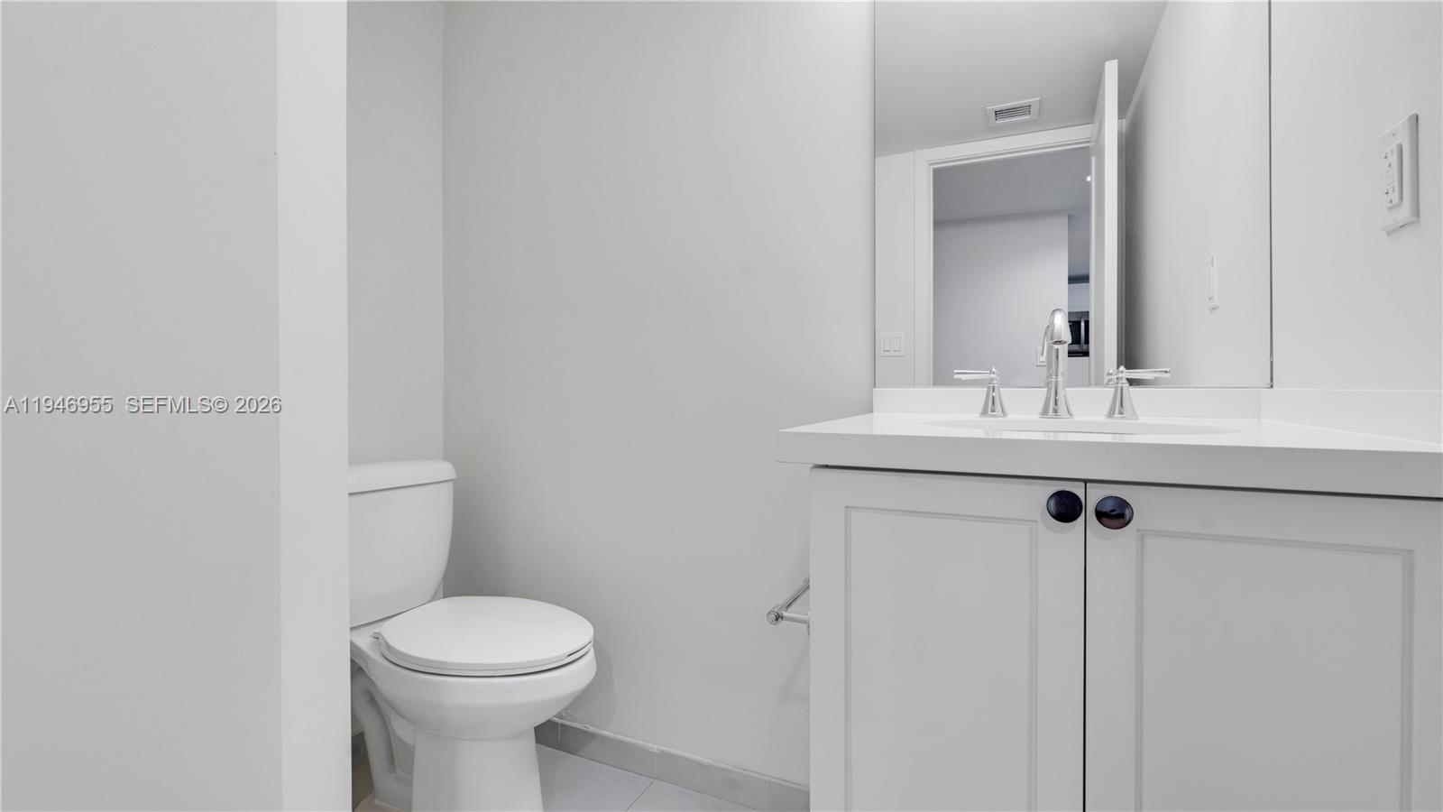 555 Northeast 34th Street, Unit 1509 Miami, FL 33137 - Photo 20 of 32 a bathroom with a sink mirror vanity and toilet
