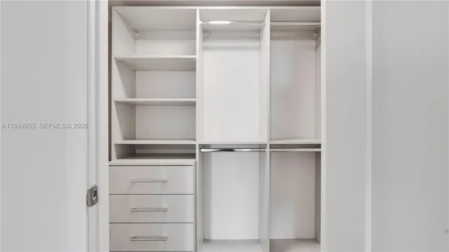 a view of empty walk in closet with wooden floor