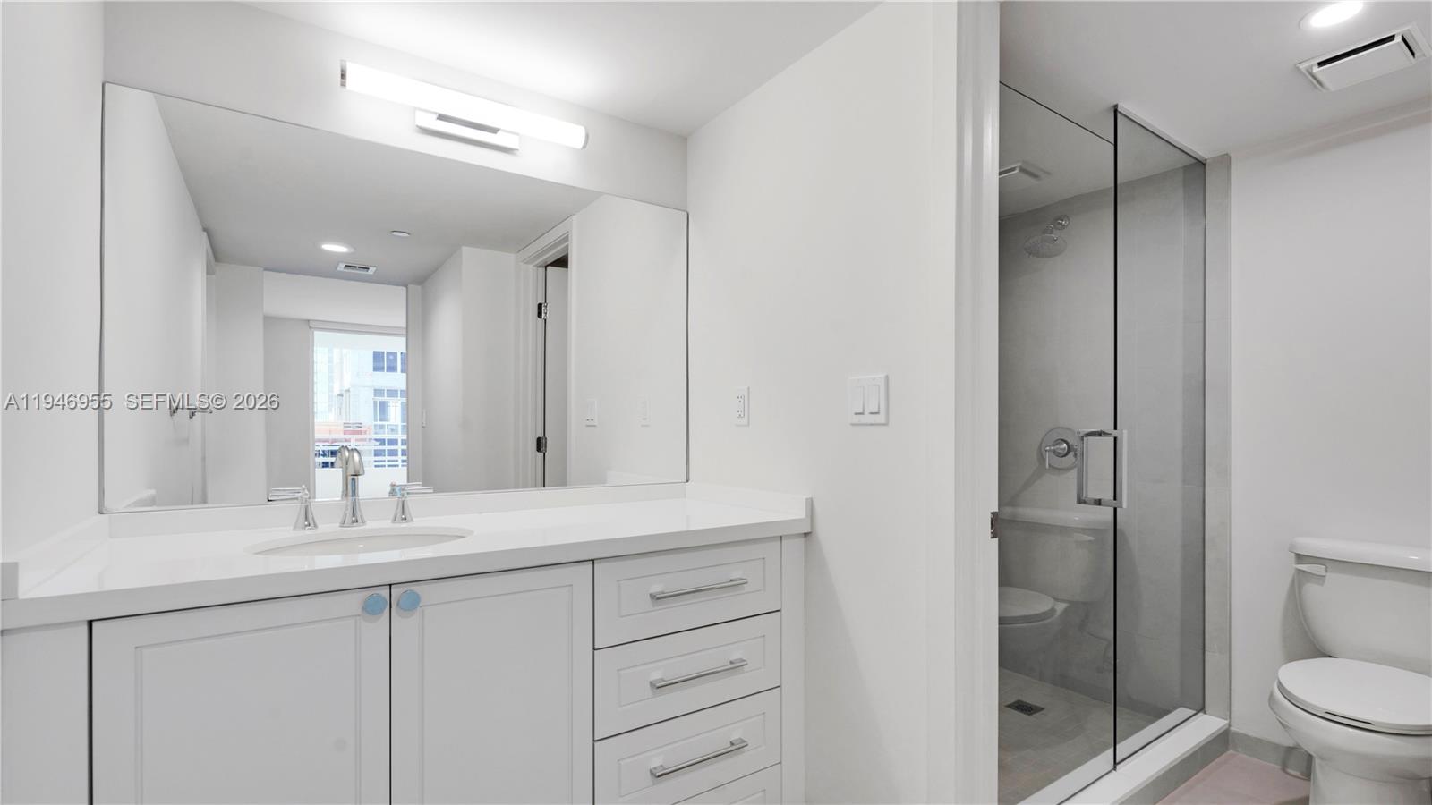 555 Northeast 34th Street, Unit 1509 Miami, FL 33137 - Photo 27 of 32 a bathroom with a double vanity sink toilet and shower